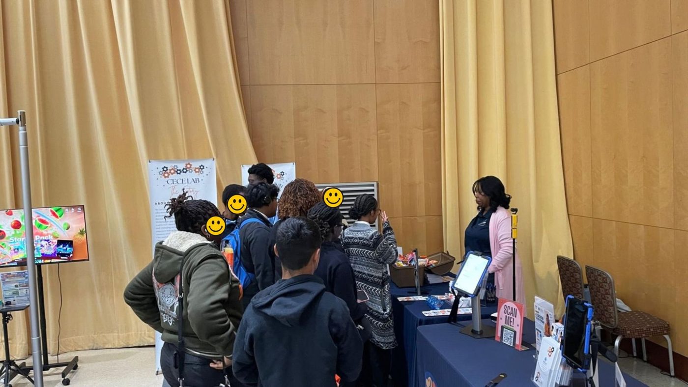 Students gather at the CECE Lab booth at the STEM Expo while a team member explains an activity